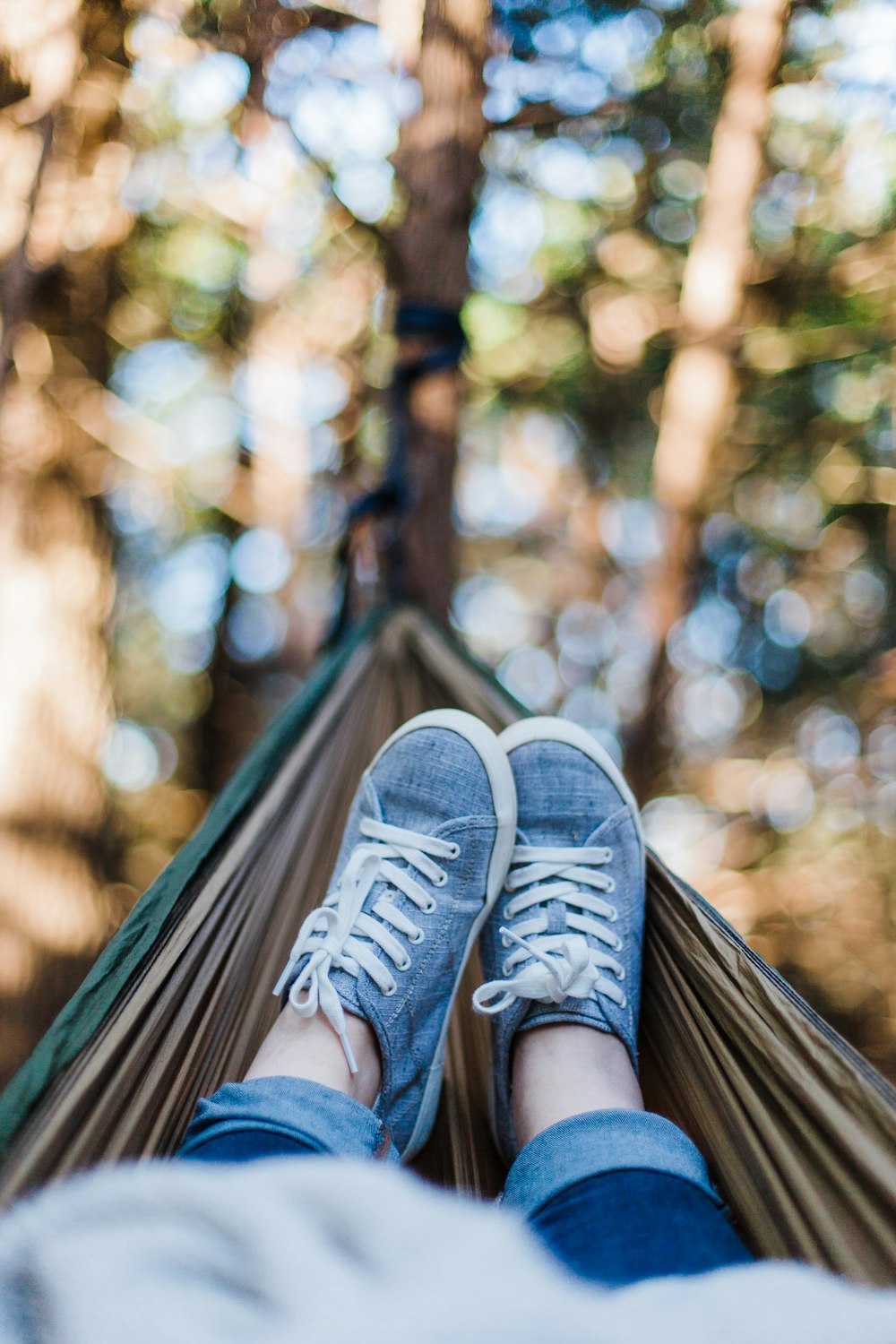 person laying down on brown hammock during daytime