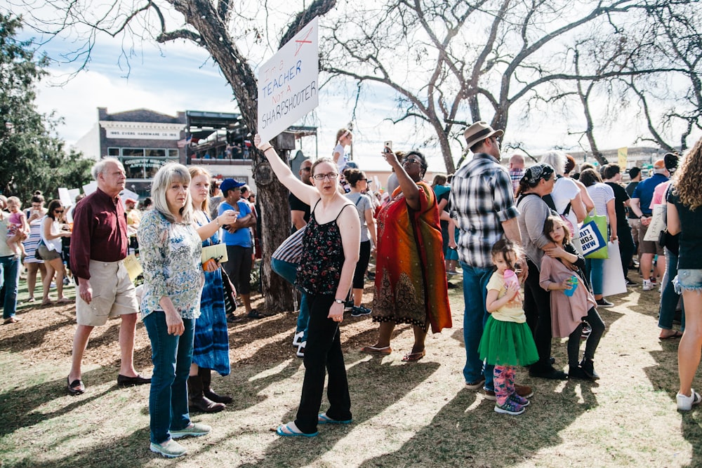 group of crowd gathering near gray bare trees during daytime