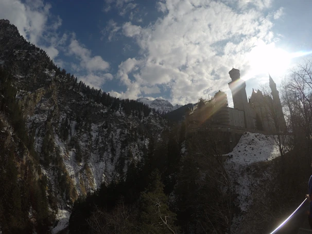 A majestic view of Karlštejn Castle perched on a hill under a bright blue sky.