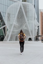 person walking toward face statue calgary