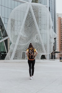 person walking toward face statue