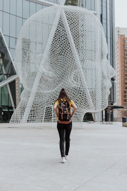 person walking toward face statue calgary
