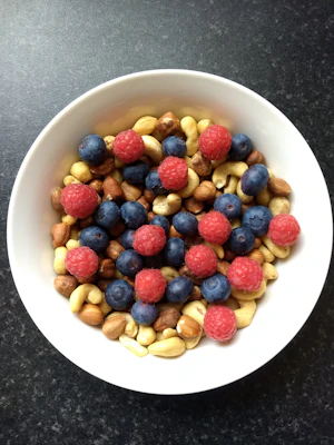 A vibrant close-up of fresh berries and nuts arranged on a wooden table, symbolizing natural energy and balanced blood sugar.
