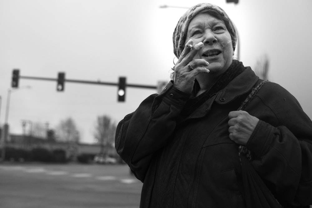 grayscale photo of woman holding cigarette stick