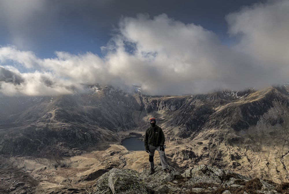 person standing on rocky mountain during daytime