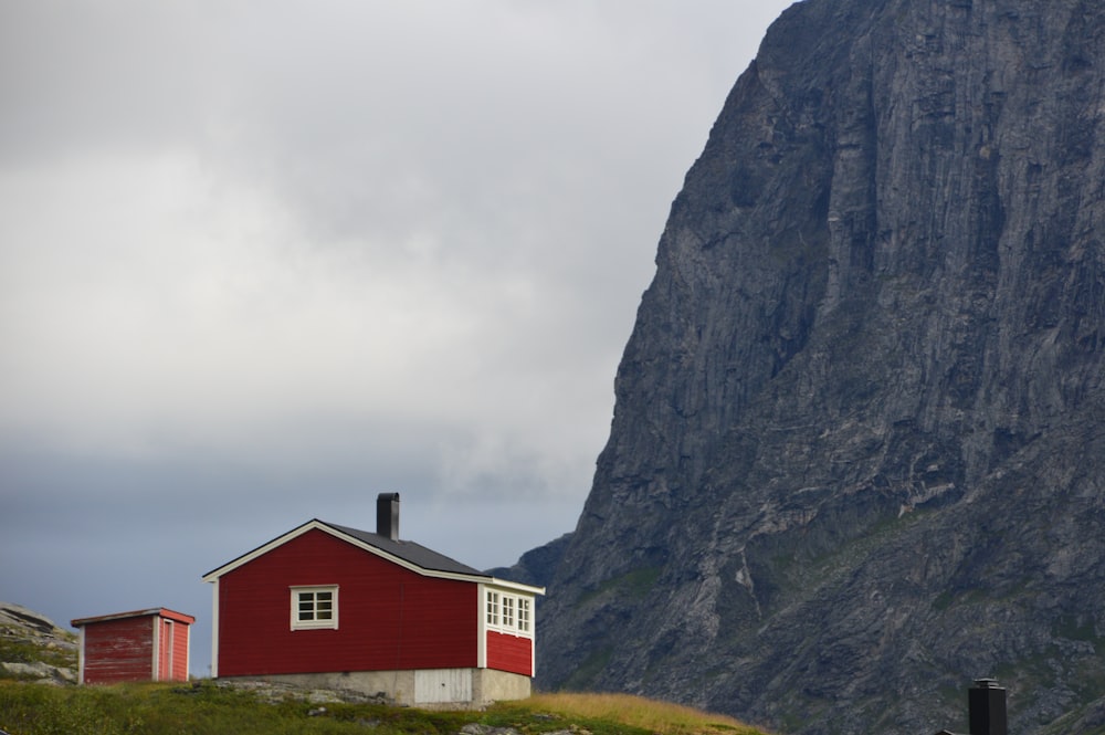 Fotografía de paisaje de la casa roja frente a la montaña marrón