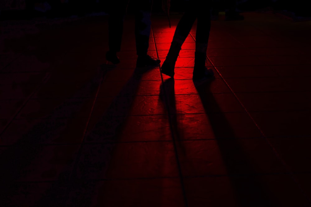 a person standing in the dark with a red light