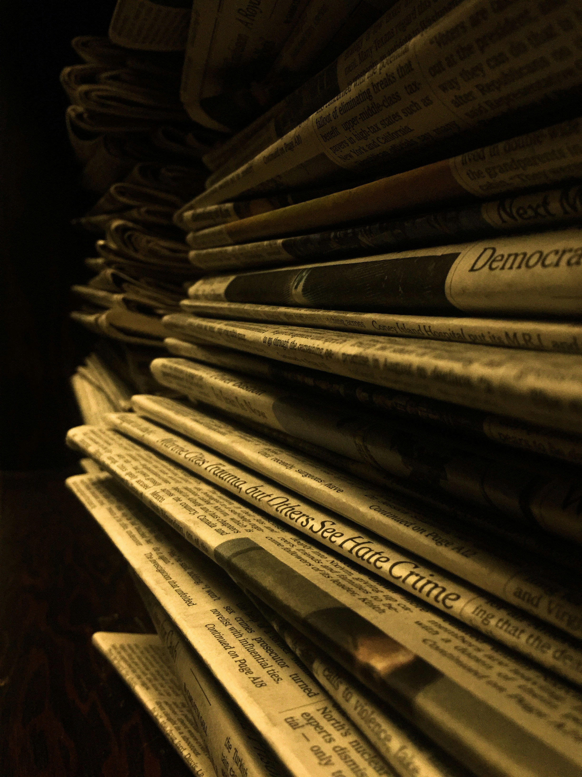 Messy stack of old documents with heavy text blocks, dim office lighting, dark background, outdated layout