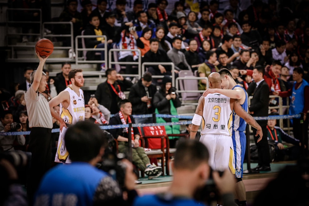 two basketball players about to hug each other at the court