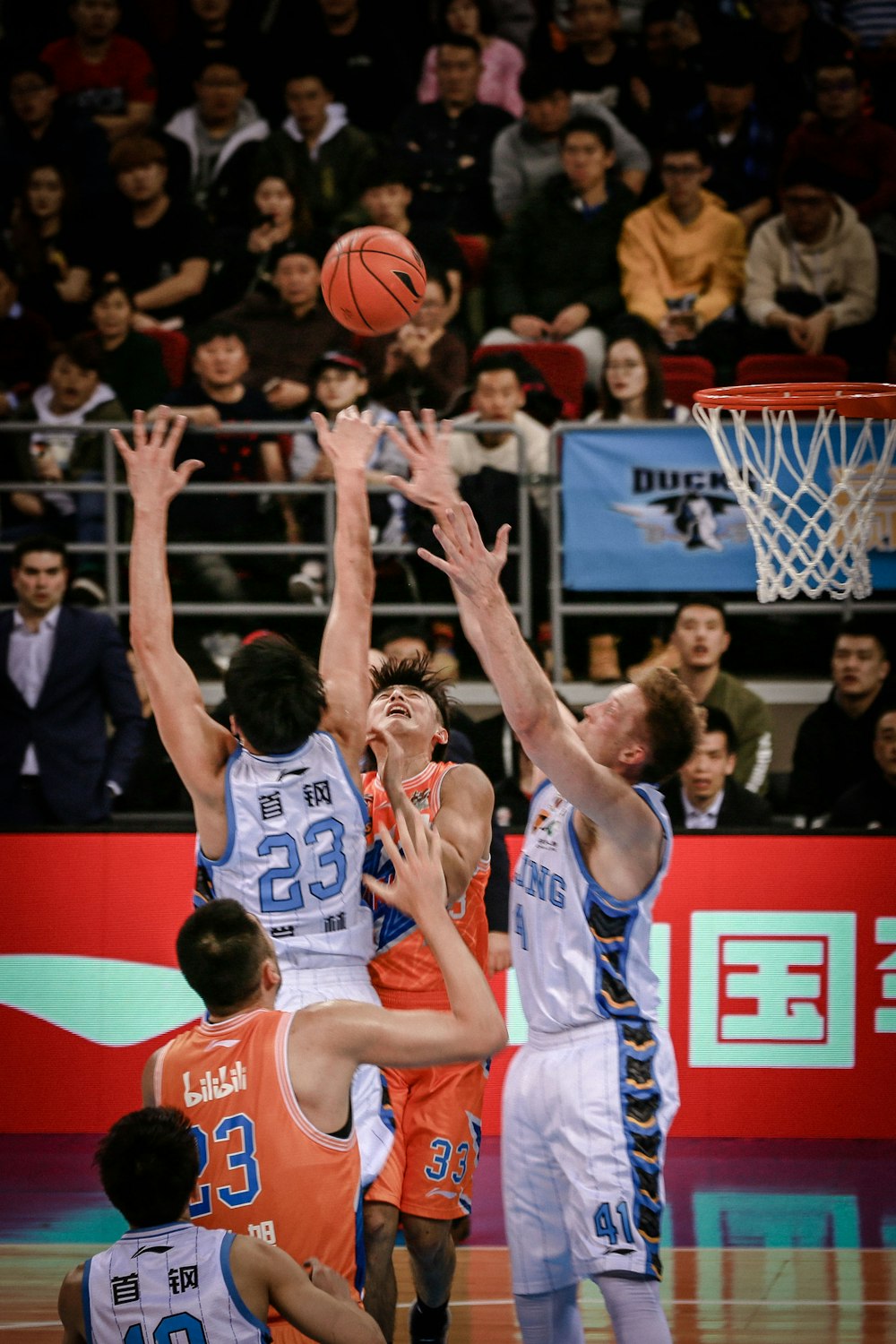 hombres jugando al baloncesto en la cancha rodeados de gente