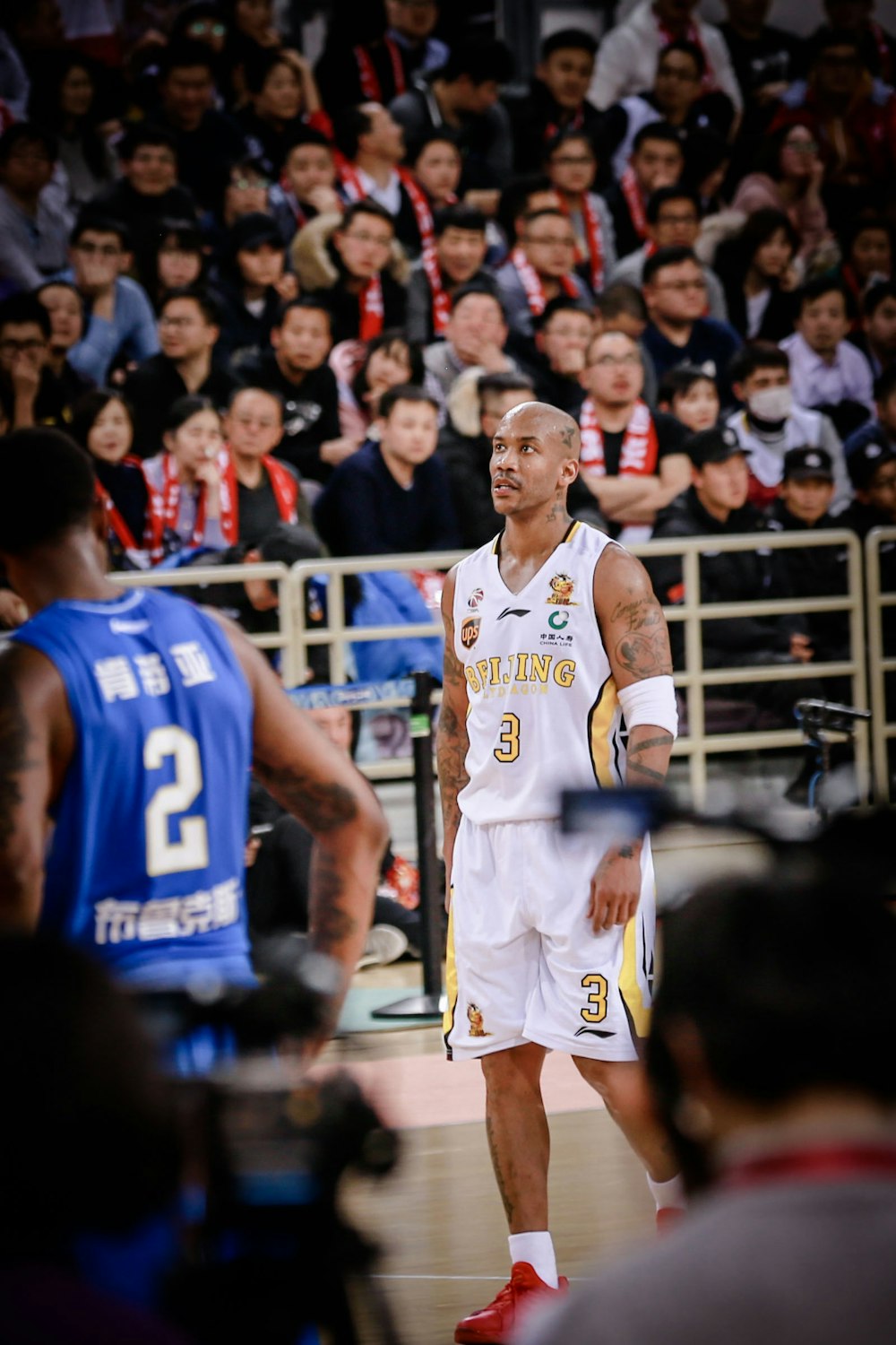 man wearing white jersey shirt near man wearing blue jersey shirt