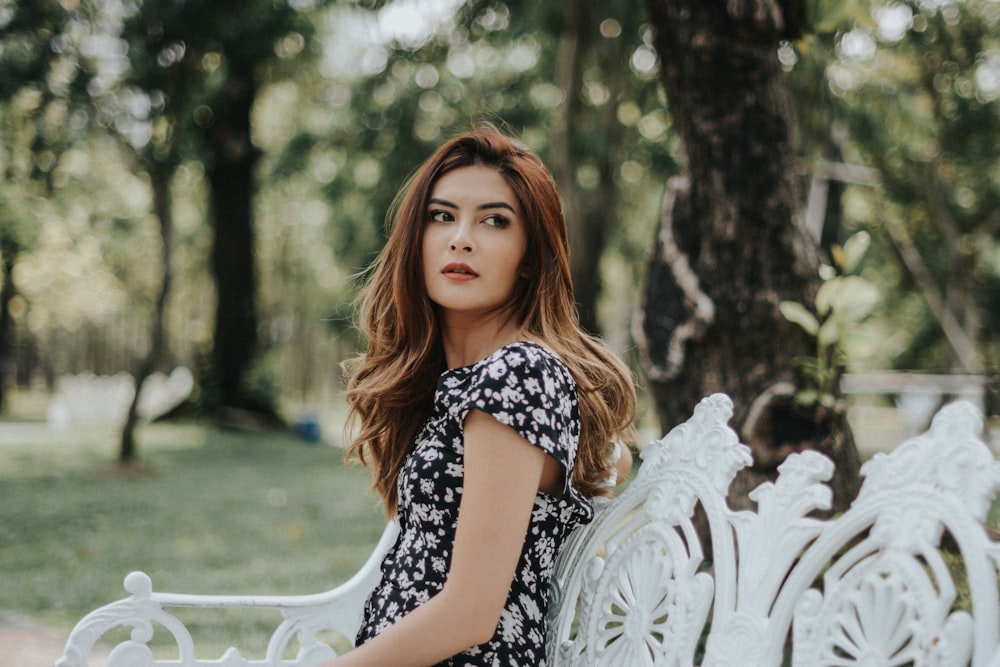 woman sitting on white bench outdoors