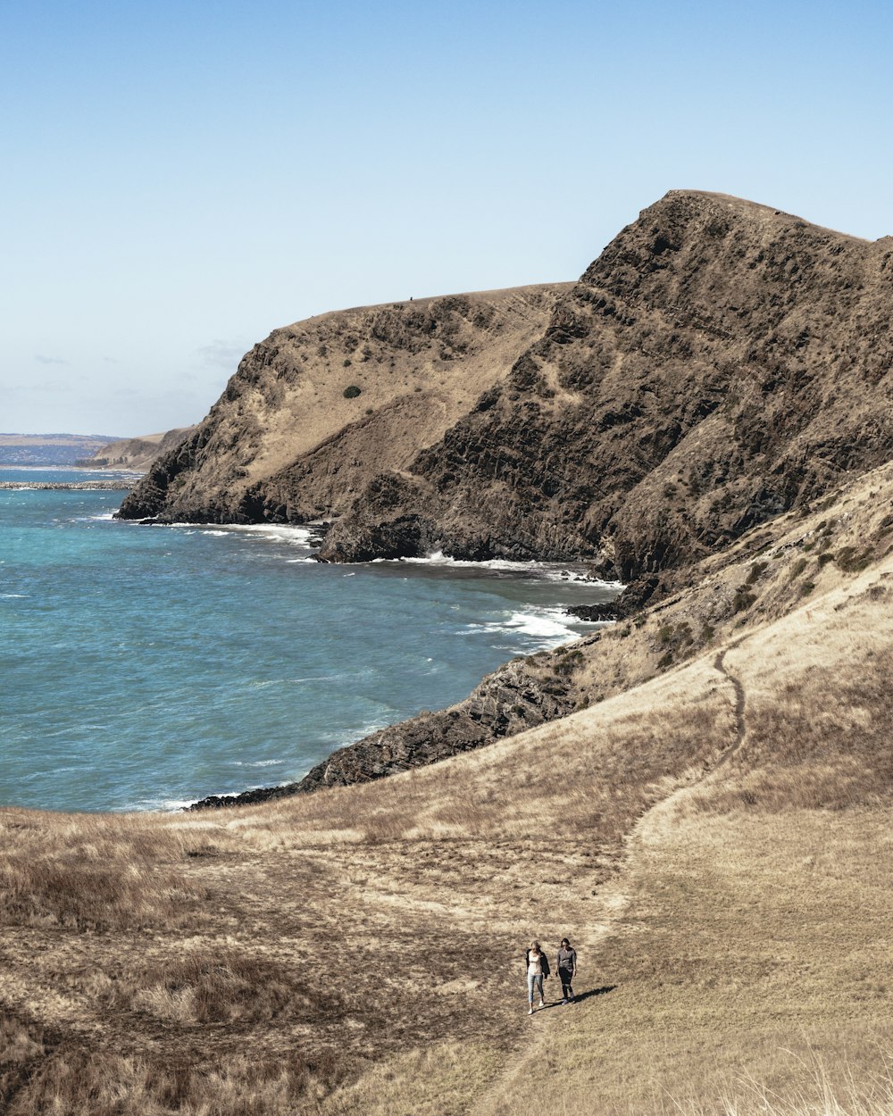 two person walking near body of water