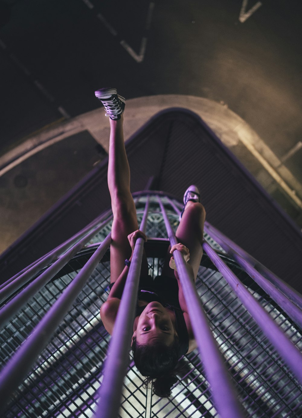 woman on purple metal tower during nighttime