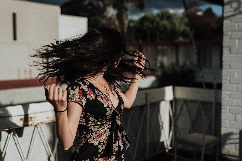 Frau schüttelt ihre Haare auf der Terrasse