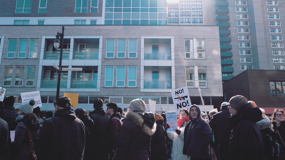 group of people gathered in street in front of building