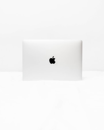 A minimalist image of a closed laptop with a distinct logo in the center. The background and surrounding area are uniformly white, emphasizing the simplicity and sleek design of the laptop.