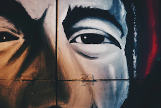 A bold close-up of a young artist intensely painting a vibrant urban mural.
