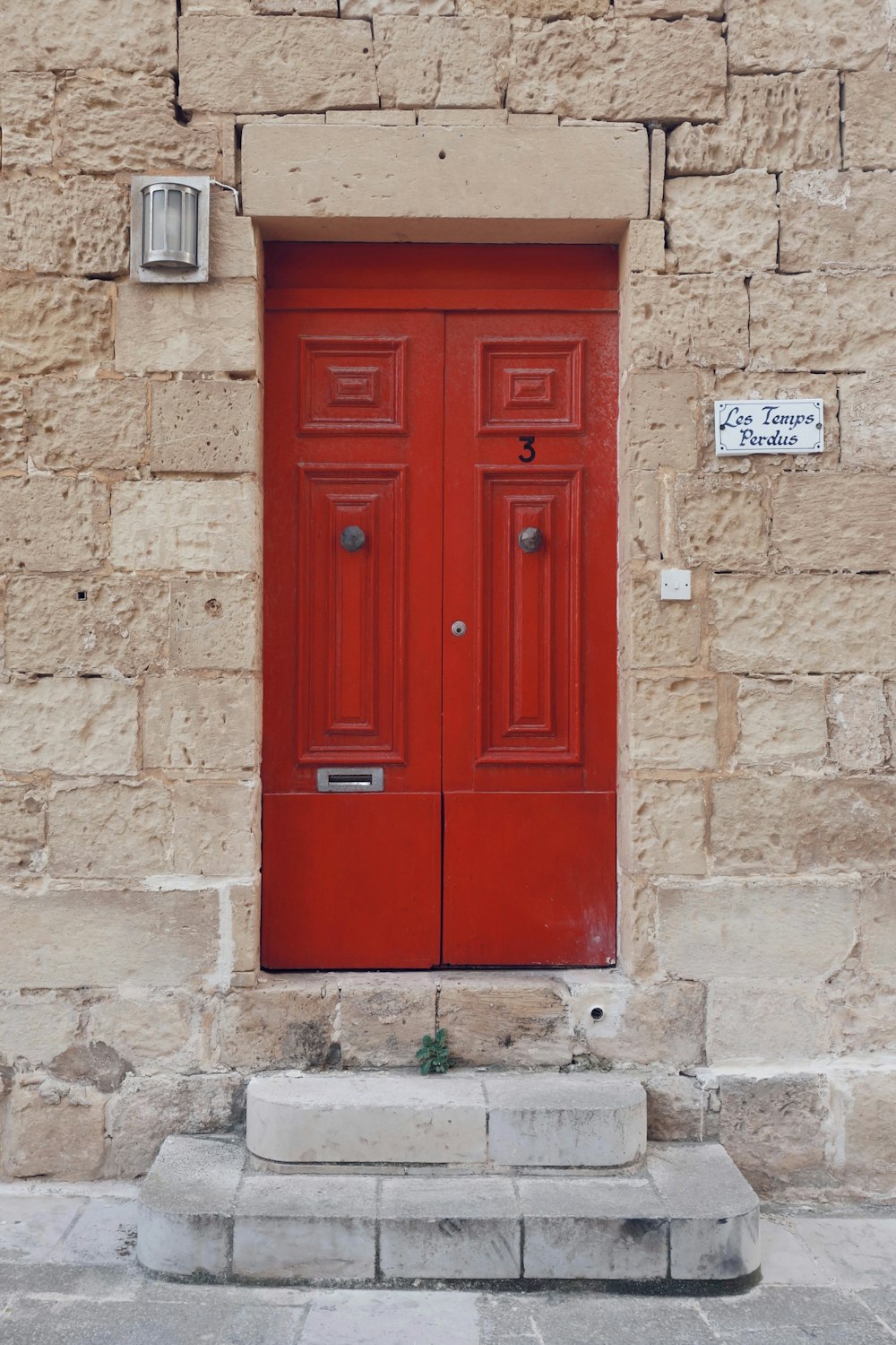 two red doors in beige brick house
