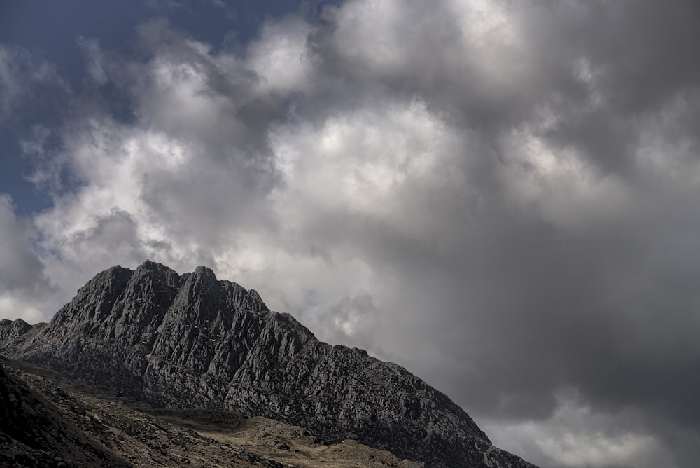 grey mountain under blue and grey cloudy sky