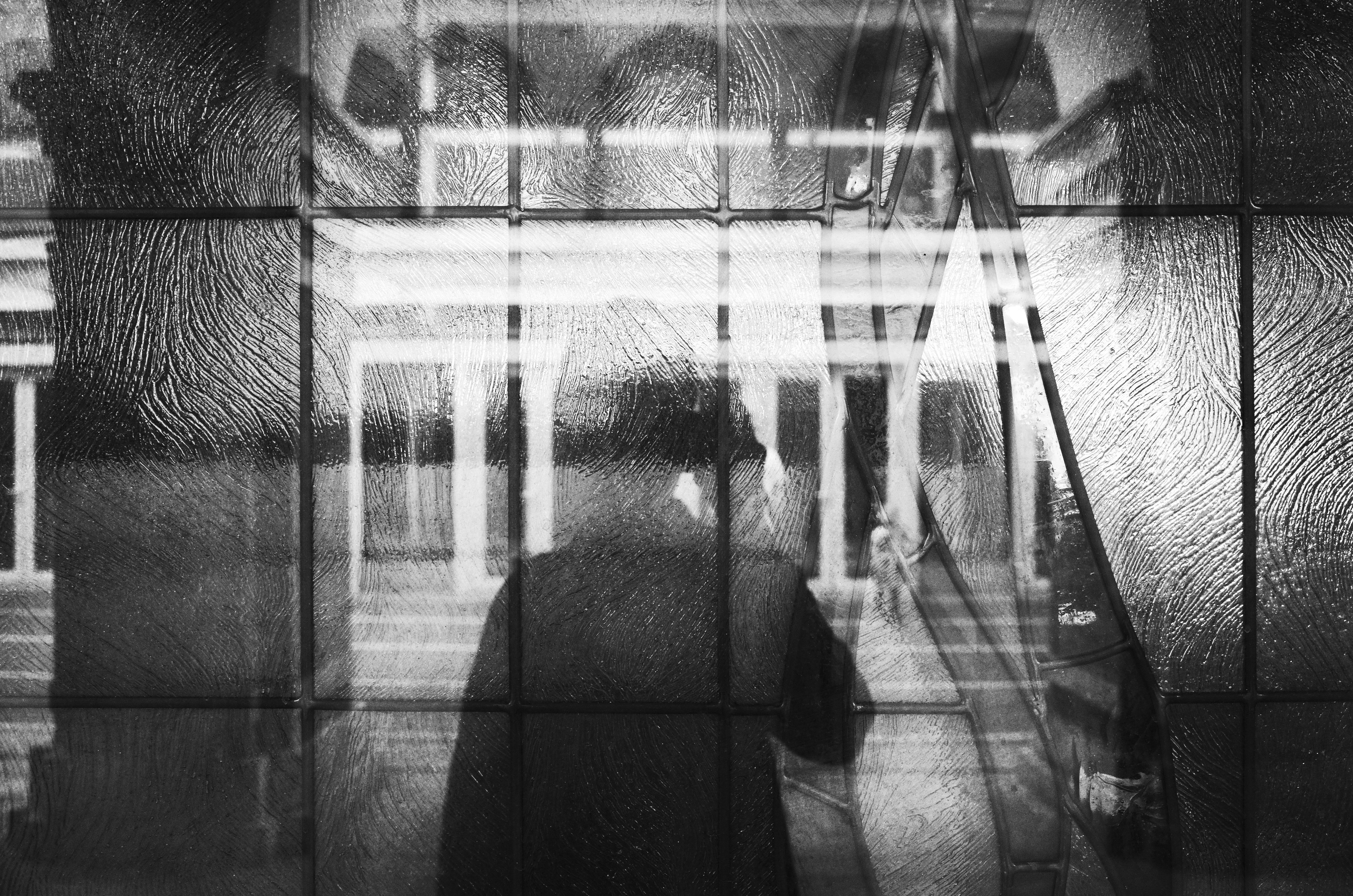 A blurry artistic black and white photo of a shadow through glass