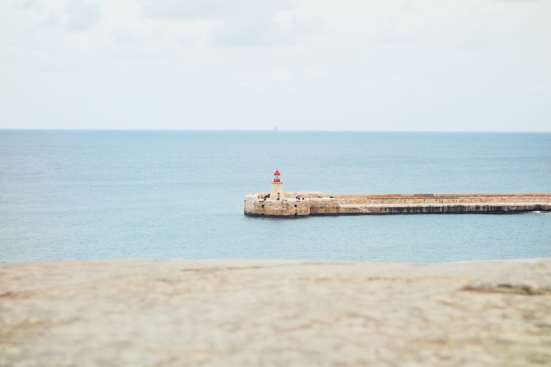 lighthouse surrounded by wide body of water, Into the blue