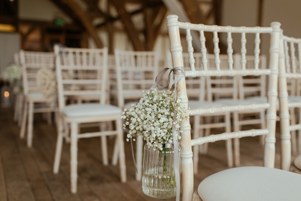 椅子に吊るされた瓶の上の白い花びらの花