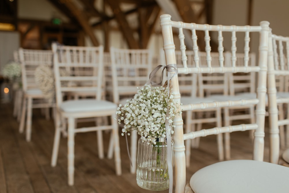 white petaled flowers on jar hang in chair