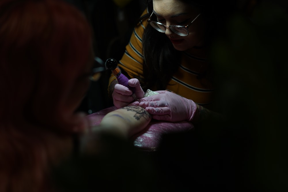 한 여자가 팔에 문신을 하고 있다