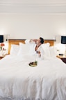 man wearing bathrobe eating on bed