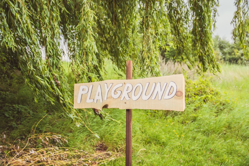 playground signage beside green leaf tree