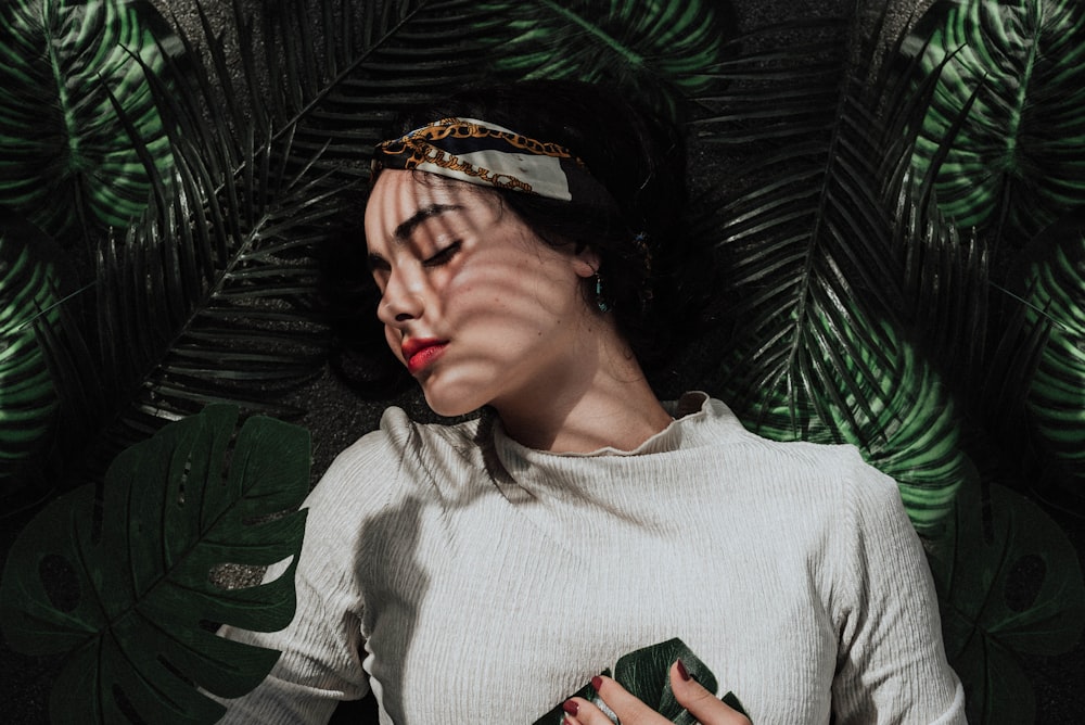 woman lying under the leaves during daytime