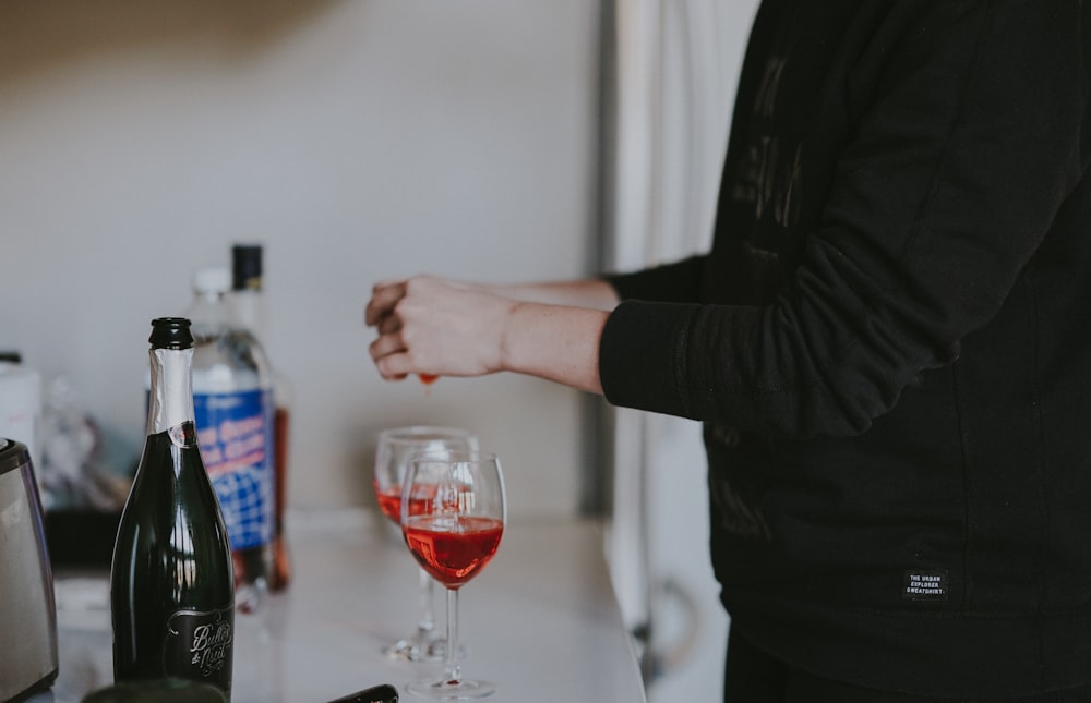 person standing beside two wine glasses