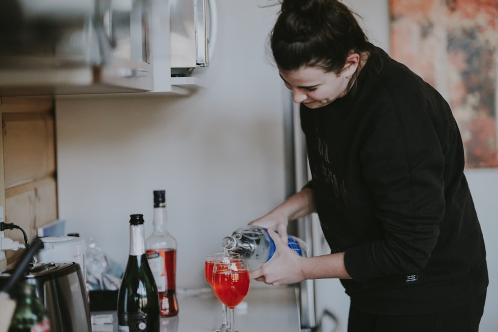 woman holding clear glass wine bottle photo