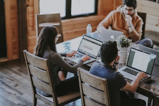 selective focus photography of woman and man using MacBook Pro on table