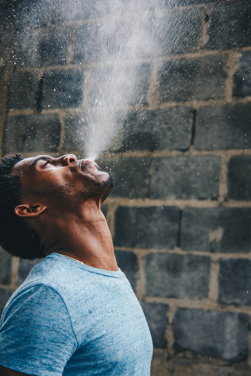 uomo che sputa acqua