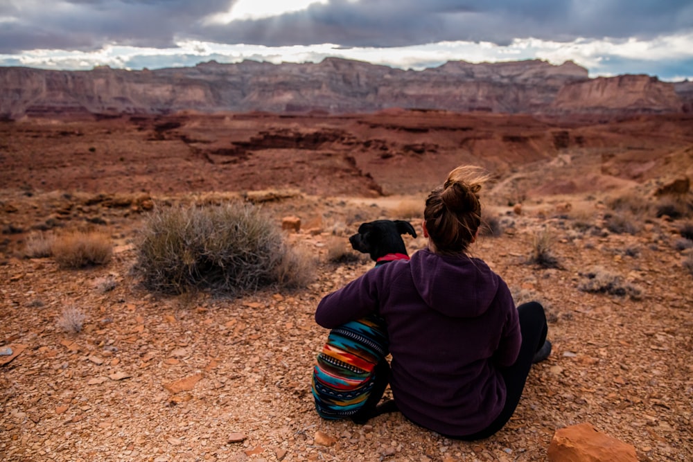 woman sitting and hugging a dog outdoors