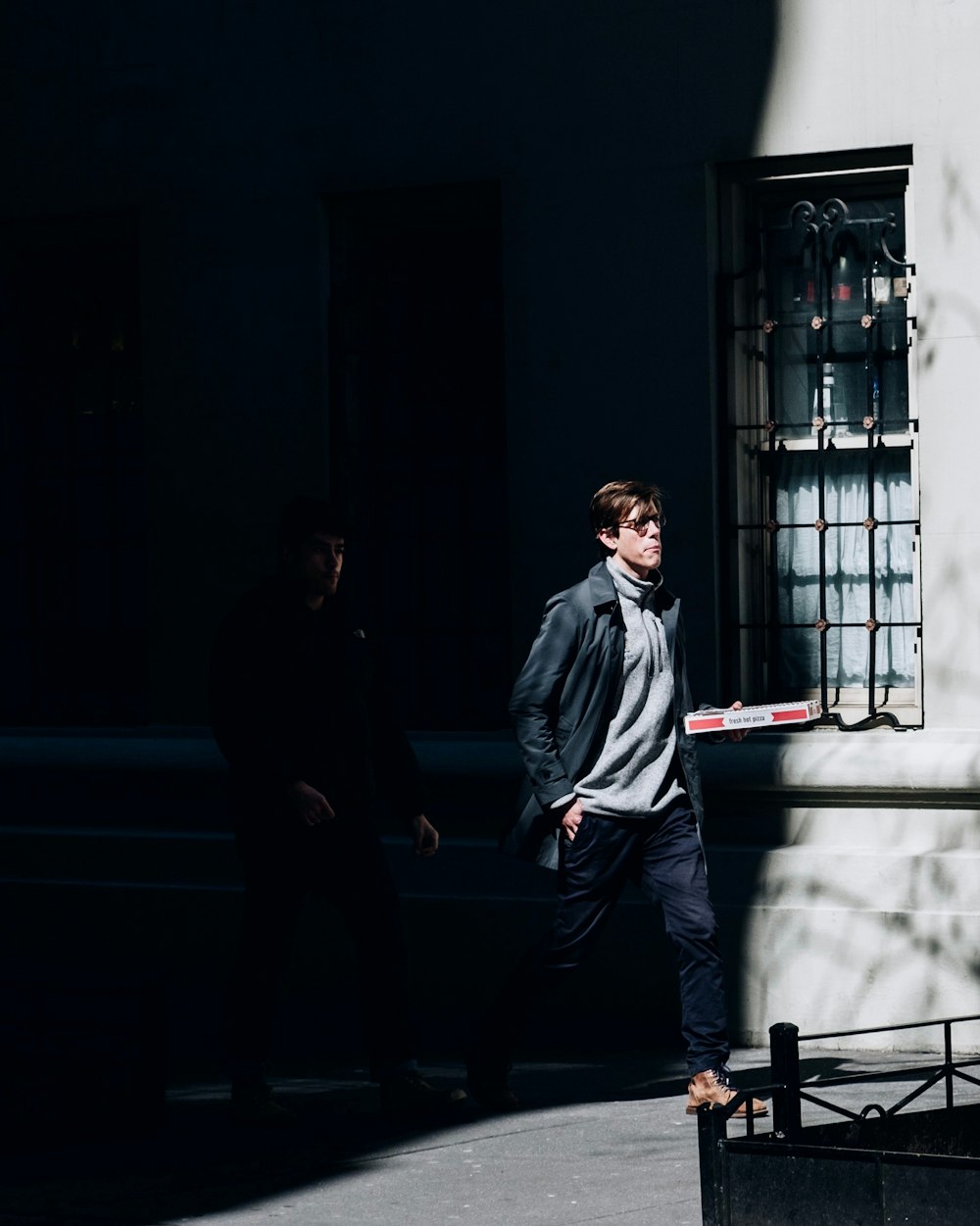 man walking while holding box during daytime