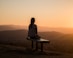 woman sitting on bench over viewing mountain