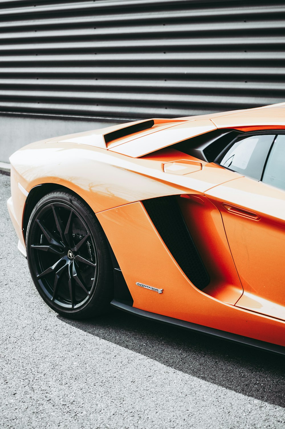 Fotografía de enfoque de coche deportivo naranja aparcado