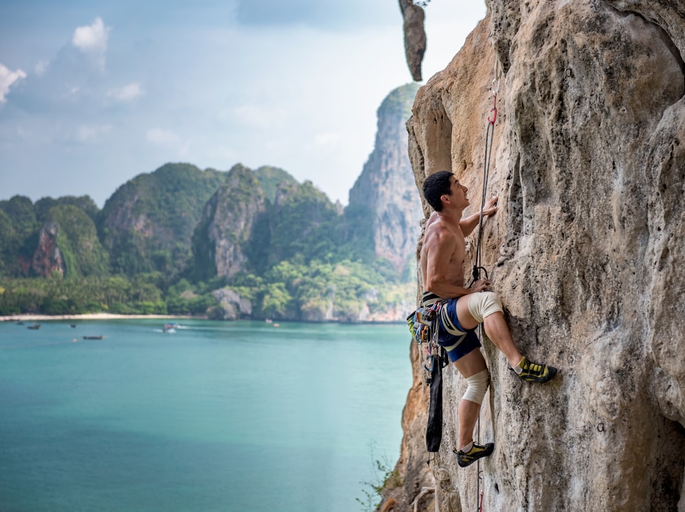 man wearing brown shirt mountain climbing at daytime