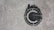 A stencil graffiti of a copyright symbol is painted on a rough concrete surface. The symbol is depicted in black with what appears to be skyline-like shapes emanating from the top half, giving it a distinctive and creative twist.