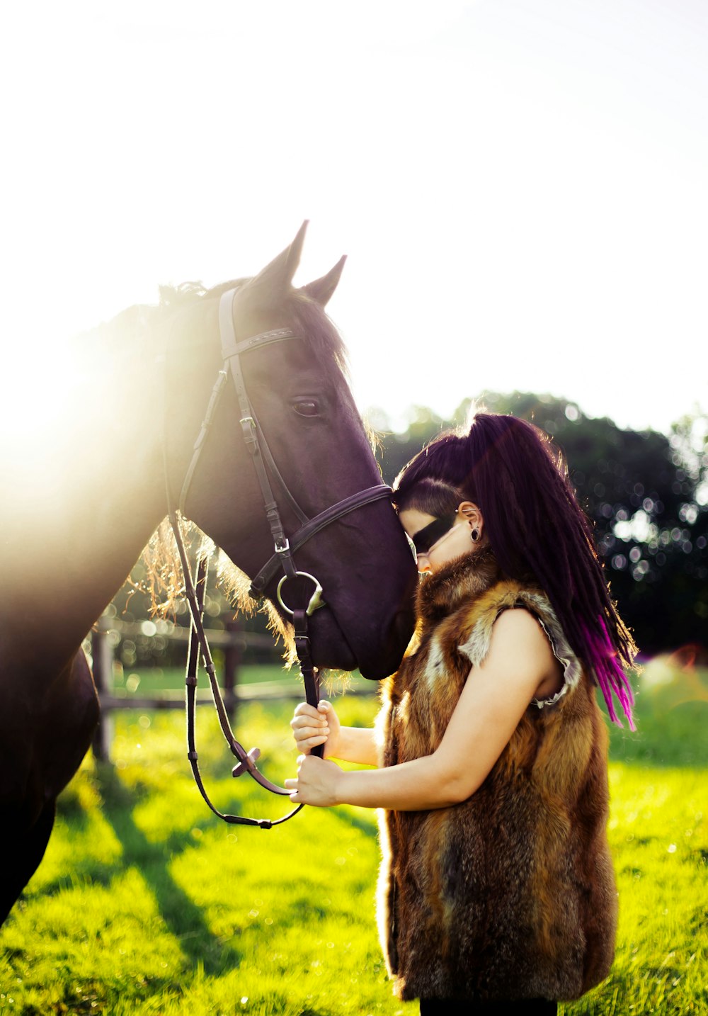 girl standing in front of horse under white clouds