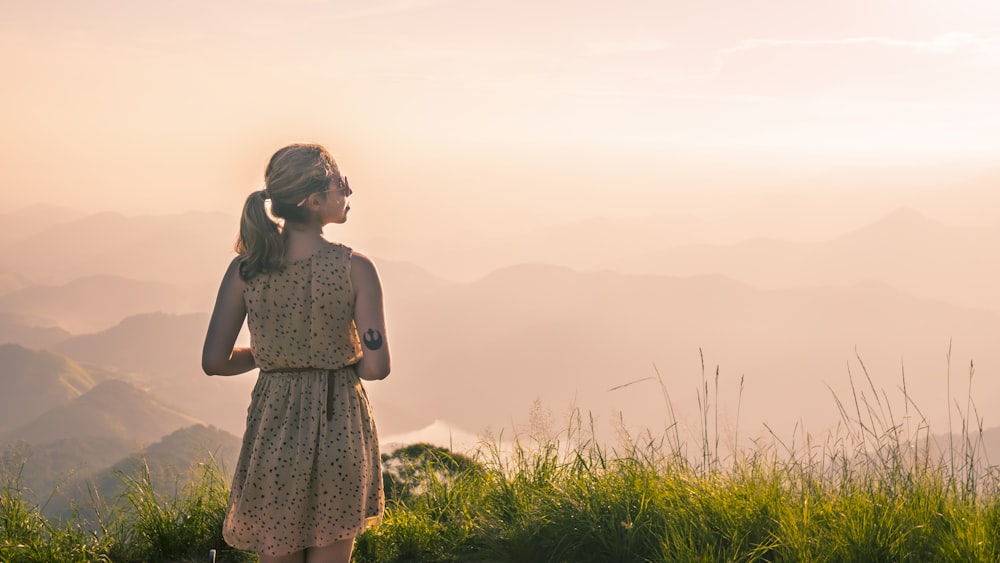 woman standing on green grass looking side