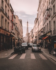 vehicles travelling on road surrounded by buildings during daytime