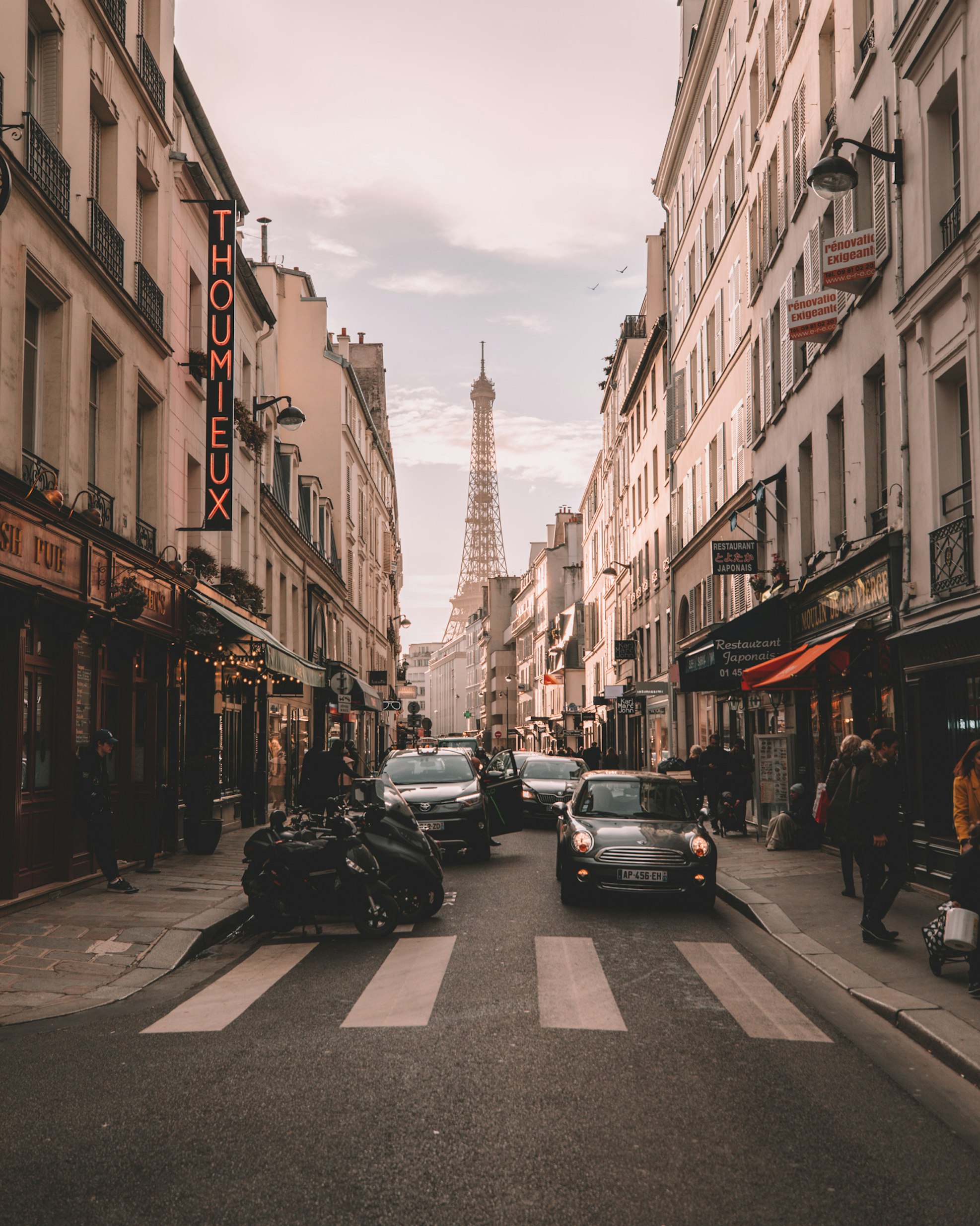 The Eiffel Tower in Paris glowing at dusk with a carousel in the foreground