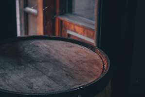 Hands holding a vintage wooden barrel with warm sunlight filtering through.