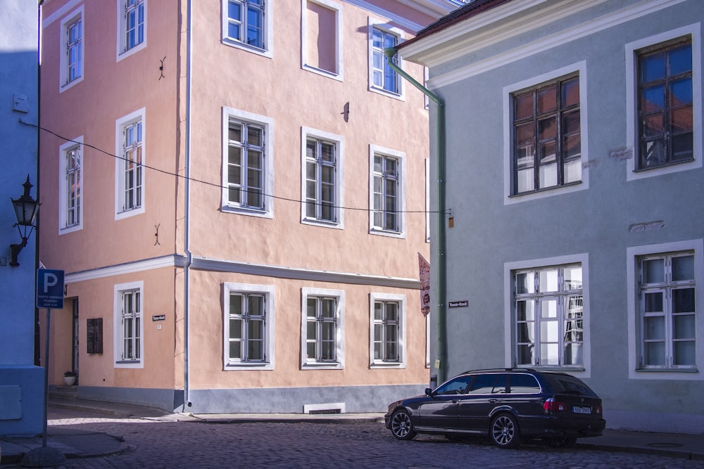 black 5-door hatchback near brown and white concrete building