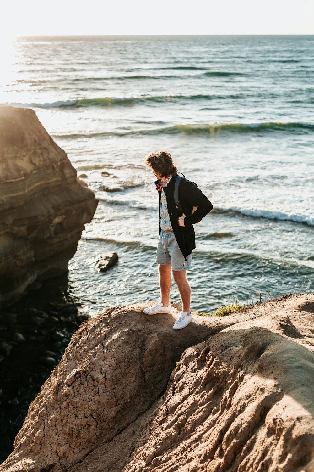 person standing on rock near sea