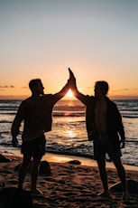 two men clapping each other on shore